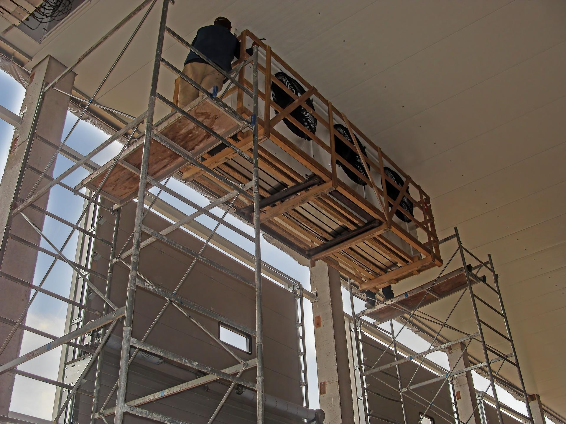 assembly works on the installation of industrial air conditioning, a large refrigerating warehouse. A worker in the forest in the process of adjusting the refrigeration equipment