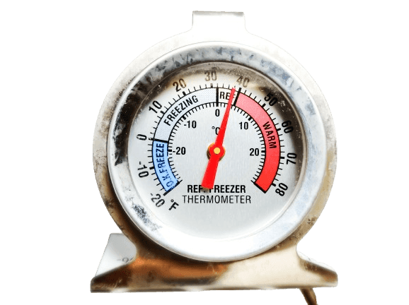 Round refrigerator thermometer with colored temperature markings from freezing to warm.